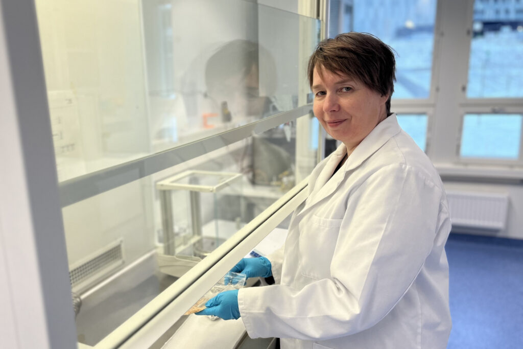 Rakentamisen elinkaaren laboratorion työntekijällä kloorianisoli näyte kädessä