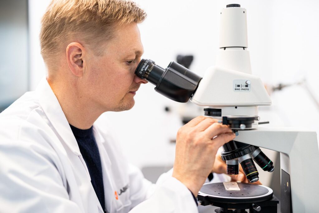 Haitta-aine ja pinnoiteanalyysin suorittaminen materiaalinäytteestä mikroskoopilla